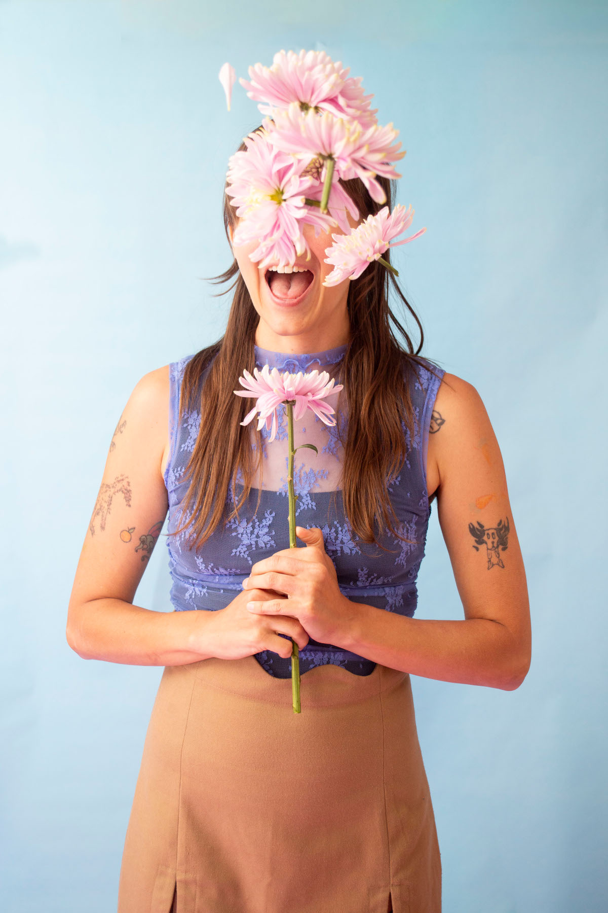 Photo of Alex with her face covered by flowers, by Laura Chapman